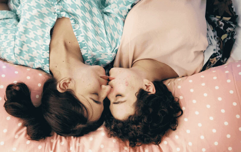 femmes lesbiennes embrasser sur un lit