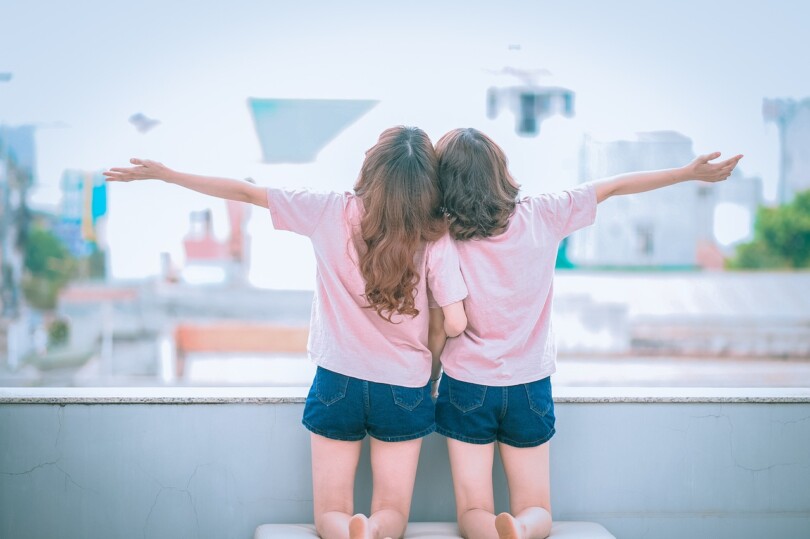 Deux femmes a genoux l’une a coté de l’autres et qui ouvre leur bras vers le ciel