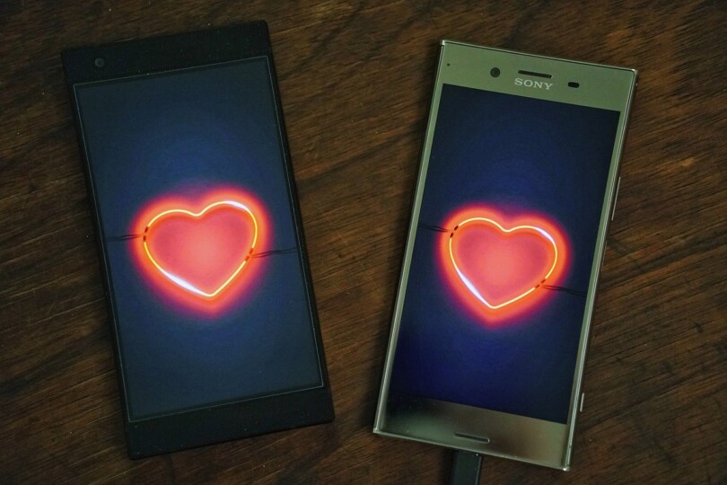 Deux téléphone avec en image de fond un coeur