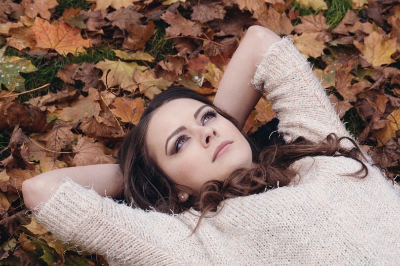 Femme pensif allongé dans l’herbe qui essaie de comprendre son dernier orgasme