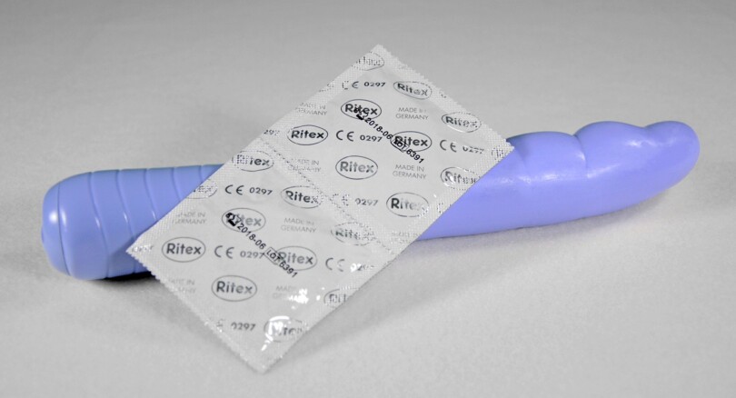 Image d’un jouets sexuels pour femme violet avec deux préservatifs posez dessus