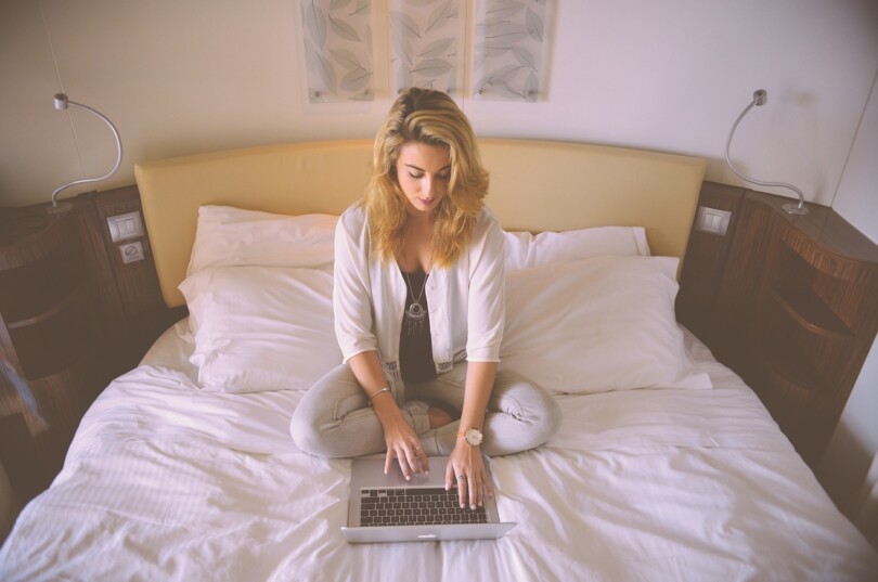 cam girl qui commence sa journée de travail assis sur son lit