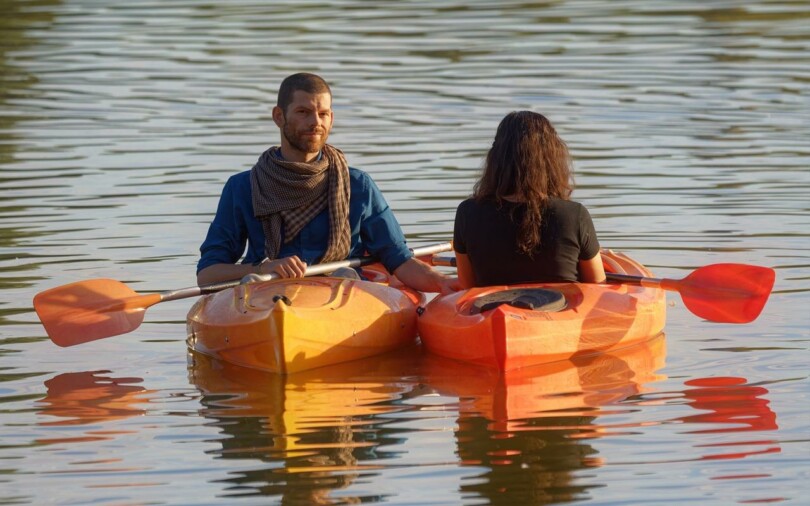 un couple s’exerce en tandem dans un kanoe kayak, perfectionnant leurs compétences en pagayant harmonieusement sur l’eau