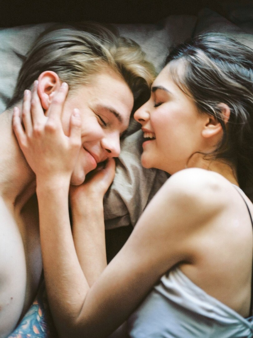 Un homme et une femme heureux allongé dans le lit qui se regarde