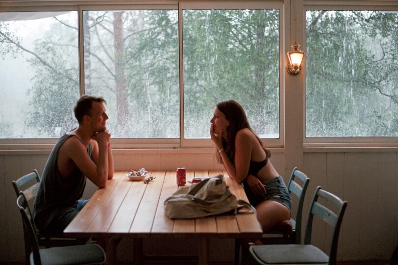 Un homme et une femme qui se souris l’un envers l’autre assis a une table