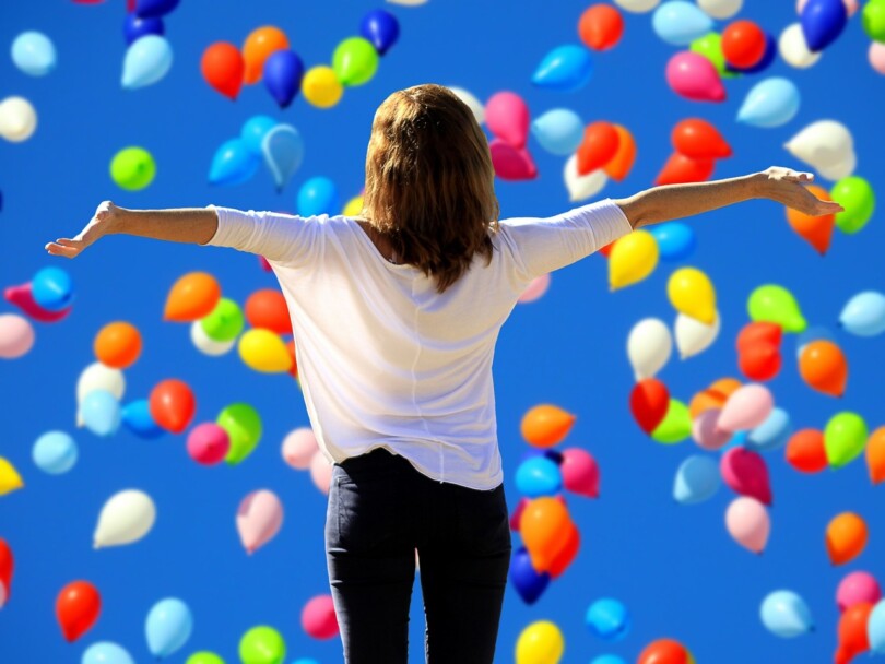 Une femme de dos avec les bras en l’air qui a retrouver confiance en elle  après une friendzone