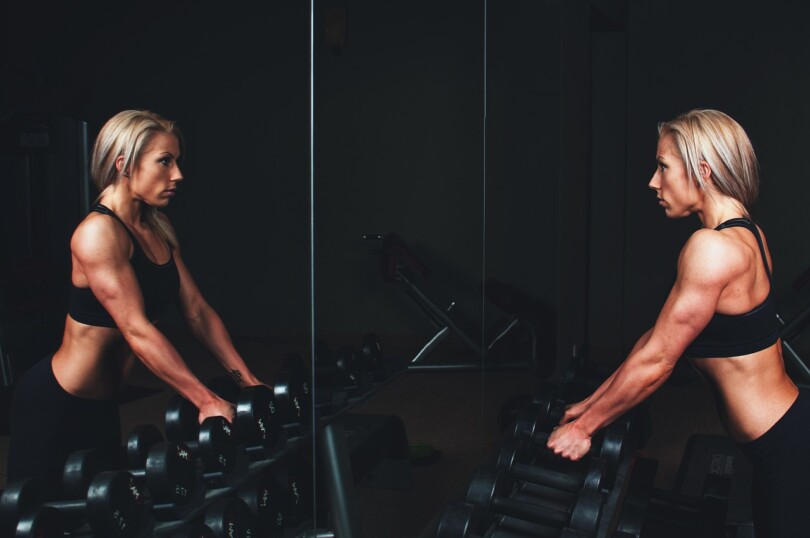 Une femme dynamique et souriante en train de faire du sport, mettant en valeur la séduction par le sport.