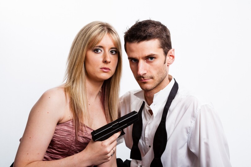 Une femme qui menace un homme avec une arme a feu, qui symbolise le manque de communication dans leur relations platonique