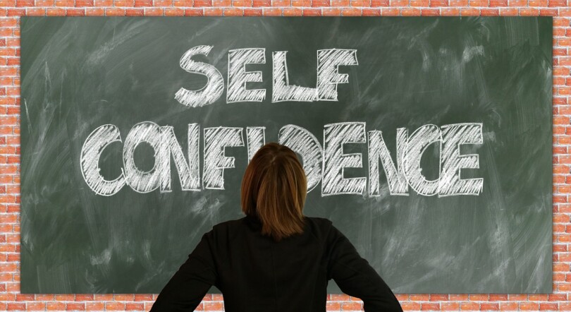 Une femme regardant un tableau ou il est écris Self confidence