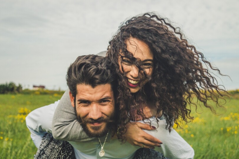 Une femme sur le dos d’un homme qui souris, qui passe un bon moment entre amis dans leur relation platonique