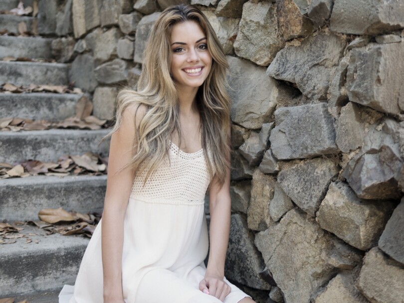 Une jolie jeune femme qui nous regardent en souriant