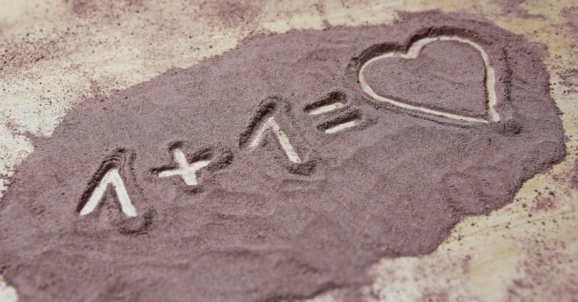 image dans le sable un plus un égale coeur dans une relation