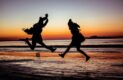 Développement personnel et rencontres en ligne : un couple qui saute en l'air sur la plage