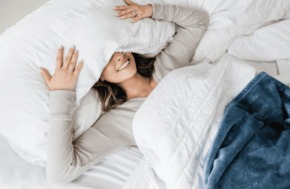 Femme dans un lit qui simule un potentiel orgasme