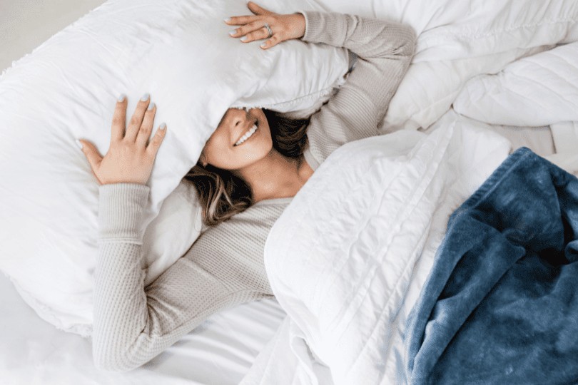 Femme dans un lit qui simule un potentiel orgasme