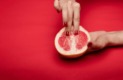 Deux doigts qui caresse l'intérieure d'une orange sanguine représentation afin de représenter le stimuli (masturbation féminine) sur les zone érogène du clitoris de la femme