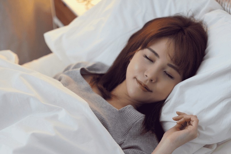 Une femme allongé dans son lit qui se masturbe sous les drap et prend du plaisir